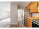 Bright kitchen with stainless steel fridge, wood cabinets, and laminate flooring at 3332 Fannin Ct, Lithonia, GA 30038