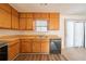 Spacious kitchen with wood cabinetry, laminate floors, and black appliances at 3332 Fannin Ct, Lithonia, GA 30038