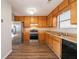 Functional kitchen with stainless steel appliances, wood cabinets, and laminate flooring at 3332 Fannin Ct, Lithonia, GA 30038