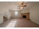 Spacious living room with a ceiling fan, fireplace, and staircase to the second floor at 3332 Fannin Ct, Lithonia, GA 30038
