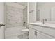 Clean bathroom with white cabinets, marble tile, and a bathtub at 590 Plainfield St, Fayetteville, GA 30215