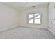 Bright bedroom with grey carpet, double doors, and a window at 590 Plainfield St, Fayetteville, GA 30215