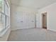 Spacious bedroom with grey carpet, large closets, and a window at 590 Plainfield St, Fayetteville, GA 30215