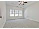 Large bedroom with grey carpet and ceiling fan at 590 Plainfield St, Fayetteville, GA 30215