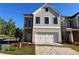 Charming two-story home featuring a two-car garage, stone accents, and vertical siding at 1074 Crest Mill Dr, Marietta, GA 30008