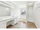 Bright bathroom featuring double sinks, large mirror, tub, and a shower with glass door at 2965 Ivy Mill Dr, Buford, GA 30519