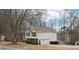 Well-maintained home featuring a two-car garage and a neatly kept lawn, highlighted by mature trees on a sunny day at 2965 Ivy Mill Dr, Buford, GA 30519