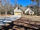 Scenic view of a home featuring a concrete driveway, two-car garage, and natural landscaping at 75 Briar Patch Rd, Covington, GA 30014