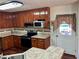 Bright kitchen with wood cabinets, granite countertops, and stainless steel appliances at 75 Briar Patch Rd, Covington, GA 30014