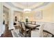 Dining room with decorative chandelier, wooden table with seating for six, and view into living room at 3693 Broughton Se Cir, Atlanta, GA 30339