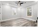 Bedroom featuring a ceiling fan, two windows, neutral walls and gray wood flooring at 358 Roy Sw St, Atlanta, GA 30310