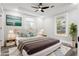 Staged bedroom with a ceiling fan, neutral walls, two windows and gray wood flooring at 358 Roy Sw St, Atlanta, GA 30310