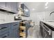 Modern kitchen with stainless steel appliances, blue cabinets, marble backsplash and gray wood flooring at 358 Roy Sw St, Atlanta, GA 30310