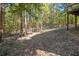 Sloping backyard with mature trees and a chainlink fence bordering the back edge of the property at 34 Clay Ct, Villa Rica, GA 30180