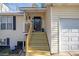 Inviting front porch with wooden steps, black front door, and adjacent two-car garage at 34 Clay Ct, Villa Rica, GA 30180