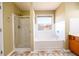 Bright bathroom with a shower, bathtub, and a window at 1188 Pine Acre Dr, Sugar Hill, GA 30518