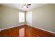 Bedroom featuring gleaming hardwood floors, ceiling fan and a window at 1188 Pine Acre Dr, Sugar Hill, GA 30518