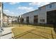 Townhome backyard featuring a grassy lawn, black metal fence, and neighboring townhome exteriors at 309 Creekbank Se Way, Smyrna, GA 30082