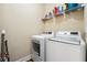 Bright laundry room featuring a modern washer and dryer set with convenient overhead shelving for storage at 309 Creekbank Se Way, Smyrna, GA 30082