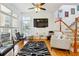 Bright living room featuring hardwood floors, staircase, and a modern black and white rug at 309 Creekbank Se Way, Smyrna, GA 30082