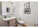 Clean powder room with a pedestal sink and decorative mirror at 309 Creekbank Se Way, Smyrna, GA 30082