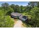 Aerial view of a single-story home featuring a two-car garage, a gravel driveway and landscaped lawn at 2334 Highway 278, Social Circle, GA 30025