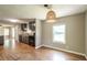 Open kitchen with wooden floors, dark cabinets, and a woven pendant light fixture at 2334 Highway 278, Social Circle, GA 30025
