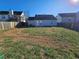 View of the home's rear elevation and backyard bordered by fences and other homes at 6531 Gina Agha Cir, Lithonia, GA 30038