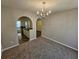 View of empty dining room showing the carpet, chandelier, and archway to kitchen at 6531 Gina Agha Cir, Lithonia, GA 30038