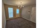 Cozy dining room featuring gray walls and carpet with a chandelier and natural light from a window at 6531 Gina Agha Cir, Lithonia, GA 30038