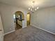 Dining room with gray carpet and a chandelier and arched openings to the kitchen and hallway at 6531 Gina Agha Cir, Lithonia, GA 30038