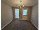 Empty dining room with a chandelier above, carpet, window, and a door to the outside at 6531 Gina Agha Cir, Lithonia, GA 30038