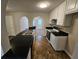 Bright kitchen featuring white cabinets, black countertops, and arched doorways to adjacent rooms at 6531 Gina Agha Cir, Lithonia, GA 30038