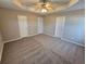 Large main bedroom with plush carpet, a ceiling fan and three doors to other rooms at 6531 Gina Agha Cir, Lithonia, GA 30038