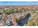 Aerial view showing a community of homes near a lake with a cityscape in the distance at 589 Lantern Wood Dr, Scottdale, GA 30079