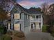 Two-story house with gray siding, a two-car garage, and a landscaped yard, at dusk at 589 Lantern Wood Dr, Scottdale, GA 30079