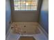 Bathroom with corner bathtub and neutral wall colors at 145 W Village W Ct, Riverdale, GA 30296
