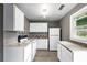 Well-lit kitchen featuring white cabinetry, tiled backsplash, and modern appliances at 2436 Clarissa Nw Dr, Atlanta, GA 30318