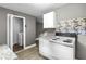 Compact kitchen showcasing appliances and a doorway with laundry closet beyond at 2436 Clarissa Nw Dr, Atlanta, GA 30318