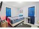 This bedroom features a comfortable bed, blue accents, and natural light from two windows at 3530 Fairlane Nw Dr, Atlanta, GA 30331