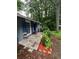 View of the side of the single-story home, showcasing blue shutters and mature trees at 3530 Fairlane Nw Dr, Atlanta, GA 30331