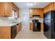 Kitchen with wood cabinets, black appliances, and tile flooring at 3100 Aberdeen Way, Lithonia, GA 30038