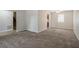 Large living room with carpeted floor and access to stairs at 3100 Aberdeen Way, Lithonia, GA 30038