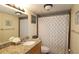 Well-lit bathroom featuring a granite countertop, modern fixtures, and a bathtub with a patterned curtain at 1150 Collier Nw Rd # 4B, Atlanta, GA 30318