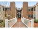 Charming exterior view with a quaint wooden bridge leading to brick apartments with trees surrounding at 511 Barrington Hills Dr, Atlanta, GA 30350
