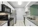 A view of the kitchen featuring stainless steel appliances, granite countertops, and white cabinetry at 511 Barrington Hills Dr, Atlanta, GA 30350
