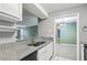 Galley style kitchen features granite countertops, stainless steel refrigerator, and an open view at 511 Barrington Hills Dr, Atlanta, GA 30350