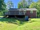 Brick house featuring a spacious wooden deck overlooking the backyard at 2467 Shady Grove Rd, Carrollton, GA 30116