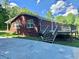 View of the back of the brick house with a wooden deck and stairs leading to the backyard at 2467 Shady Grove Rd, Carrollton, GA 30116