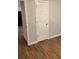 Hallway with wood floors and neutral walls, leading to a door and an adjacent room at 2467 Shady Grove Rd, Carrollton, GA 30116